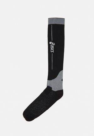 Sorte kompressionssokker med lysegrå accenter. Har tætsiddende sål og forstærket hæl. "Asics"-logoet trykt i hvid. Knæhøj design.