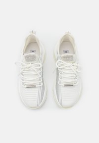 Weiße Sneaker aus Mesh und glattem Leder, mit silbernen Akzenten, strukturierten Mustern und dekorativen Schnürsenkeln.