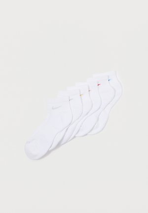 Valkoiset nilkkasukat, joissa on harmaa Nike-logo ja värikkäitä tehosteita punaisena, sinisenä ja keltaisena. Pehmeä rakenne, jossa on ribbikujetteet. Kuuden sukan setti.