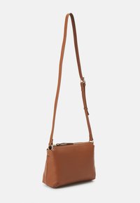 Brown leather crossbody bag with a smooth texture, zip closure, adjustable strap, and gold-tone hardware. Compact rectangular shape.