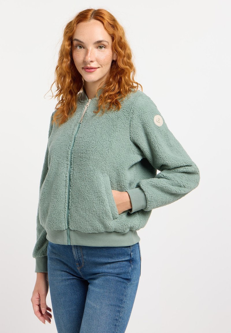 Fleece bomberjack in zacht mintgroen met een ritssluiting aan de voorkant, geribde manchetten en een patch op de mouw. Voorzien van zijzakken en een gestructureerde stof.