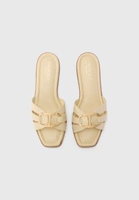 Light beige slide sandals with a square toe, featuring layered straps and a gold-tone buckle accent. Smooth leather and stitched detailing.