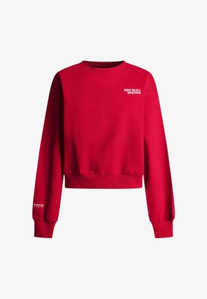 Czerwony krótki sweter z jasnoczerwonej bawełny, z prążkowanym dekoltem typu crew i długimi rękawami. Logo "Red Bull Racing" nadrukowane na biało.