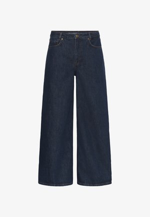 Donkerblauwe denim jeans met wijde pijpen, voorzakken, ceintuurlussen, knoopsluiting en zichtbare stiksels.