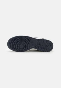 Sneaker blu navy con suola in gomma testurizzata, caratterizzata da motivi di battistrada circolari e verticali per una presa sicura, realizzata in materiali sintetici.