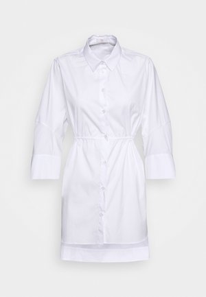 Abito camicia bianco con colletto, maniche a tre quarti, vita cinchata e orlo dritto. Realizzato in tessuto leggero e morbido.