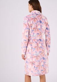 Accappatoio a fiori con sfondo rosa, caratterizzato da fiori blu e pesca. Realizzato in un morbido tessuto testurizzato, con maniche lunghe e una cintura.