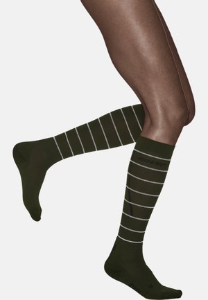 Calze alte verde scuro con strisce orizzontali bianche, caratterizzate da una morbida texture e una vestibilità aderente, ideali per comfort e supporto.