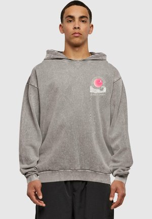 Gray hoodie with a loose fit and ribbed cuffs. Features a pink graphic design on the chest with sun and wave motifs. Soft texture.