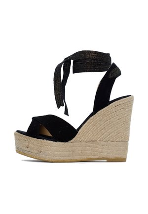 Sandali con zeppa in suede nera con suola in juta intrecciata, dotati di una ampia fascia sulla punta e lacci alla caviglia per una vestibilità regolabile.
