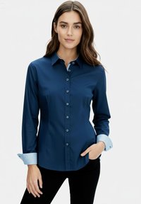 Navy blue button-up shirt with long sleeves and a light blue striped cuff. Smooth fabric with a tailored fit and classic collar design.