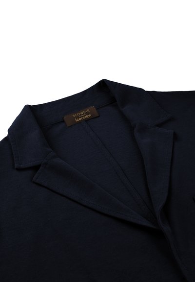 Navy blue cotton shirt with a pointed collar, smooth texture, and a tag labeled "SLOWEAR icecotton." Front button placket visible.