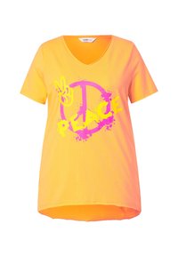 T-shirt jaune vif à col en V avec une coupe ample, arborant un signe de paix rose et un graphique "PEACE" en couleurs vives, fabriqué en coton doux.