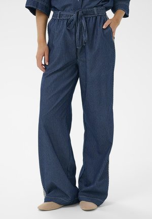 Pantaloni larghi blu navy in tessuto leggero con sottili righe bianche, dotati di vita regolabile e tasche laterali.
