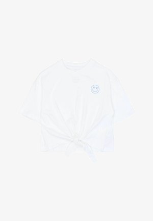 Valkoinen puuvillainen lyhythihainen t-paita, lyhyt malli, etuosassa solmukoriste ja vasemmassa ylärinnassa sininen hymynaamapistos.