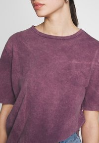 Lila, något urtvättad bomulls-t-shirt med rund halsringning och korta ärmar, med en avslappnad passform och subtil textur.