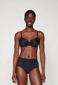 Set di biancheria intima nera composto da un reggiseno imbottito e morbido con spalline regolabili e slip a vita alta con pannelli laterali in rete per una maggiore traspirabilità.