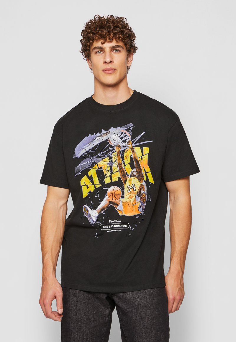 Čierne bavlnené tričko s farebnou grafikou basketbalistu, ktorý smečuje, a s výrazným nápisom "ÚTOK" v tučných žltých písmenách.