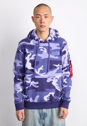 Lila kamouflage hoodie med dragsko, framficka och ribbade ärmar. Har en logotypapplikation och en röd etikett på ärmen.