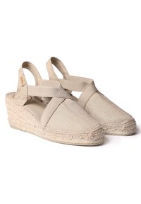 Beige plátěné espadrilky na wedges s elastickými popruhy a tkaným juty středem podrážky. Zaoblená špička a texturovaný povrch látky.