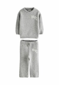 Grijze gebreide trui en broek set met geribbelde manchetten, met een witte "NYC" graphic op beide stukken. Zachte textuur en casual stijl.