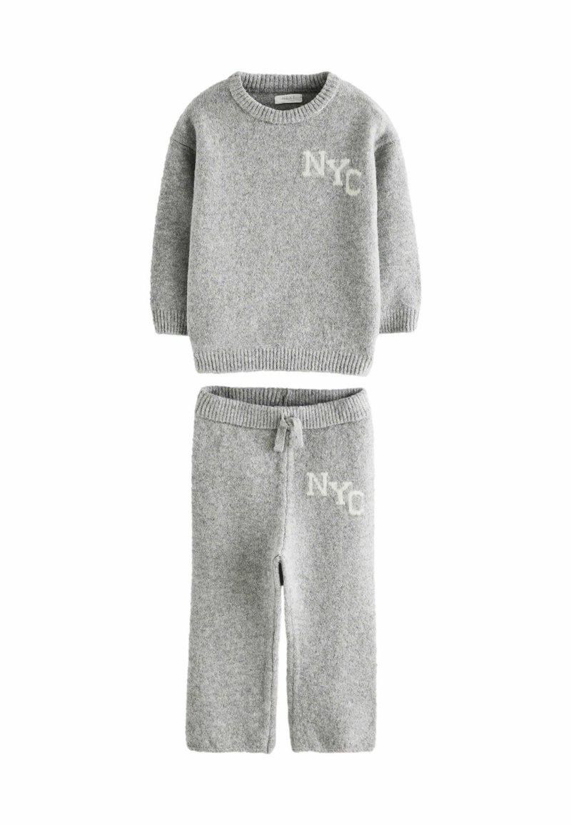 Grijze gebreide trui en broek set met geribbelde manchetten, met een witte "NYC" graphic op beide stukken. Zachte textuur en casual stijl.