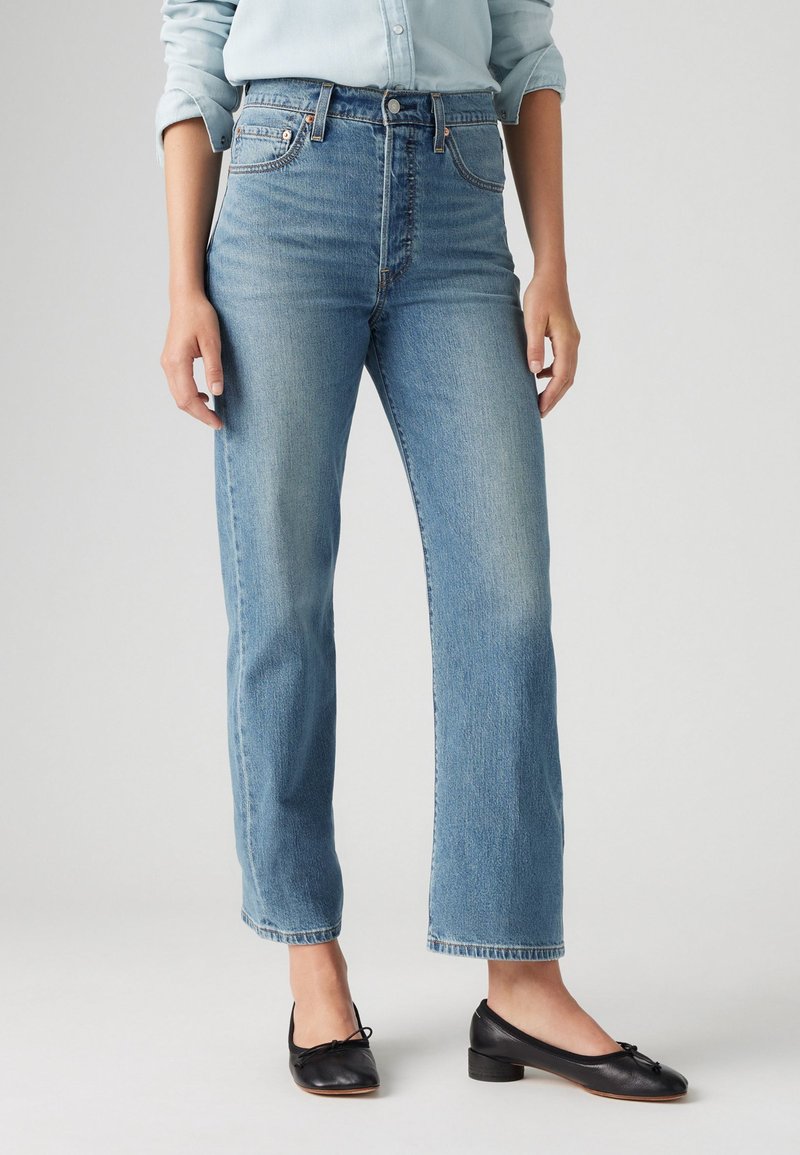 Ljust blå höga jeans med rak benform, blekt mönster och klassisk femfickdesign. Matchas med svarta ballerinas.