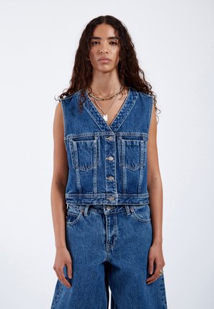 Denim gilet met een v-hals, zilveren knopen aan de voorkant en twee borstzakken. Lichtblauwe wassing met een ontspannen, cropped pasvorm.