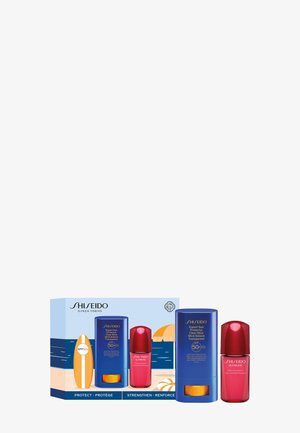 Shiseido Sonnenschutz- und Hautpflegeset mit SPF 50+ transparentem Stick und rotem Serumfläschchen, verpackt im Strandthema.