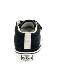 Zapatilla alta de ante negra con suela de goma blanca, que presenta una franja blanca en la parte trasera y un logotipo de la marca visible en el talón.