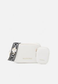 Vit läder crossbody-väska med en avtagbar ficka, guldfärgade detaljer och en svart-vit rem med "VALENTINO" text.