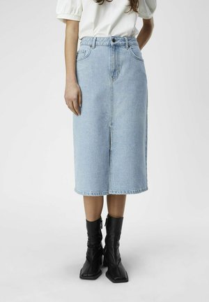 Ljusblå denim midi-kjol med rak skärning, detalj med mittsöm framtill, fem fickor och knäppning med knapp, i kombination med svarta ankle boots.
