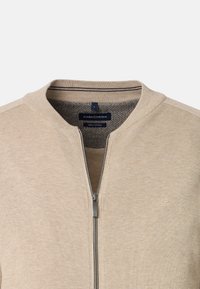 Beige zip-up sweatshirt i bomull med en texturerad krage, randiga detaljer och en diskret logotyp på vänster bröst.