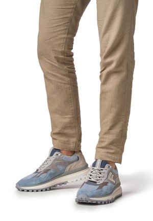 Lichtblauwe en grijze sportschoenen met gestructureerde panelen, vetersluiting en een dikke zool met een antislipprofiel.