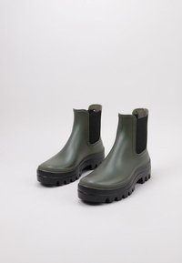 Botas de tobillo de goma verde con lados texturizados, paneles elásticos y suelas con un profundo relieve para mejorar el agarre. Acabado suave y diseño de punta redonda.