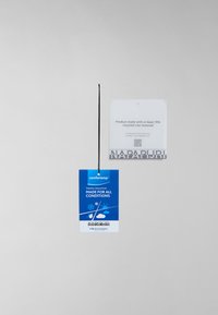 Etiqueta rectangular azul con el logo "comforttemp" y detalles de aislamiento térmico. Cuerda negra adjunta. Etiqueta blanca detrás con nota de reciclaje.