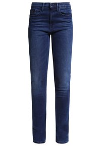 Jean en denim bleu foncé avec une coupe slim, cinq poches, fermeture à bouton et légères décolorations sur les cuisses pour plus de texture.