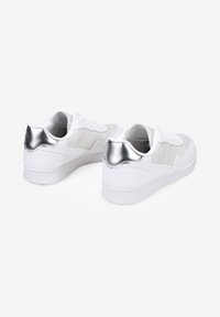 Weiße Sneakers mit einer glatten Leder- und Wildleder-Oberfläche, die metallisch silberne Akzente an der Ferse und ein klassisches Schnürdesign aufweisen.