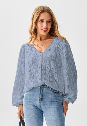 Lichtblauwe, gestructureerde cardigan met een V-hals en gegolfde randen. Voorzien van ingewikkelde breipatronen en knoopsluiting; ballonmouwen.