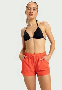 Haut de bikini noir, avec des fines bretelles ; short de bain orange vif avec taille élastique et cordon de serrage, stylé avec des poches latérales.