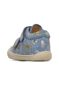 Blå mocka barnskor med en texturerad beige sula, prydda med ett färgglatt mönster av dinosaurier och ett kardborreband för enkel av- och påtagning.