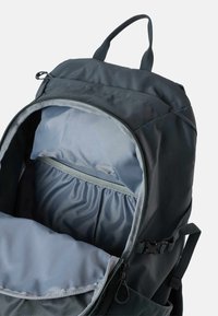 Sort og grå rygsæk med åbnet hovedrum, der viser polstret laptoplomme og inderlomme.