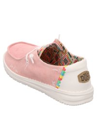 Scarpa slip-on in tela rosa con cuciture decorative e fodera in tessuto a fantasia. Suola bianca con una patch del logo sul tallone.