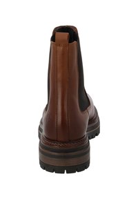 Bruna läder Chelsea-boots med svarta elastiska sidopaneler, kontrasterande staplad klack och texturerad gummisula. Diskret logotypdetalj på baksidan.