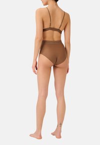 Bra in Braun ohne Nähte und hochgeschnittene Unterhosen aus weichem Material. Mit verstellbaren Trägern und einem elastischen Bündchen mit Logo.
