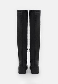 Botas negras hasta la rodilla hechas de cuero liso con un diseño simple, que presentan cremalleras laterales y un tacón grueso para mayor estabilidad.