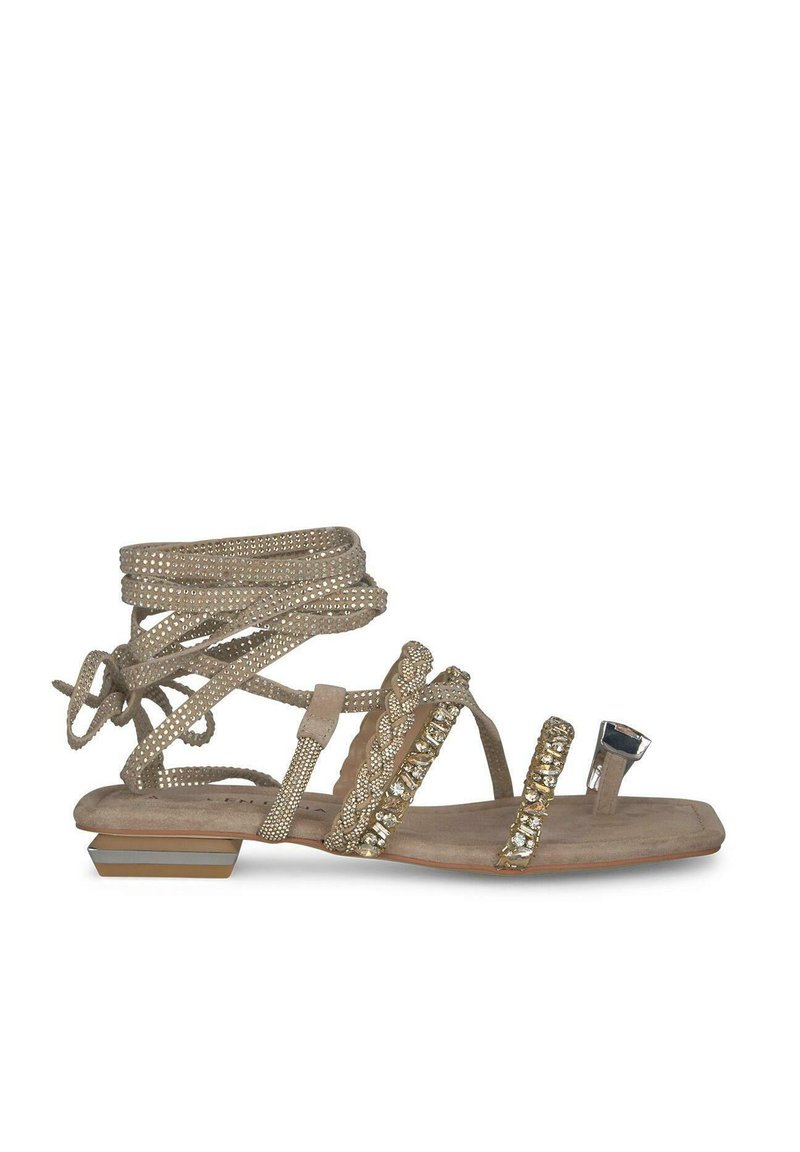 Sandal beige con molte cinghie scintillanti, punta aperta, tacco basso a blocco e accenti decorativi. Texture liscia con suola piatta.