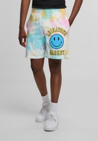 Pastelfarvede tie-dye shorts med en blå smiley face grafik og teksten "CHINATOWN MARKET". Fremstillet af blødt stof med elastisk talje.