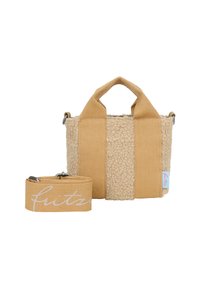Pequeño bolso tote beige con dos asas de tela anchas, cuerpo de forro de textura de borreguito y correa de hombro a juego, desmontable, con escritura en cursiva.