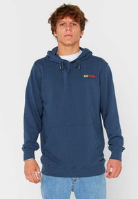 Granatowa bluza z kapturem wykonana z mieszanki bawełny, z przednią kieszenią typu kangur, kapturem ze sznurkiem oraz haftowanym logo "RIP CURL" w kolorowych literach.